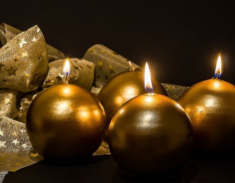Vier runde goldene Kerzen brennen, im Hintergrund ist ein goldenes Band mit Sternen verziert.