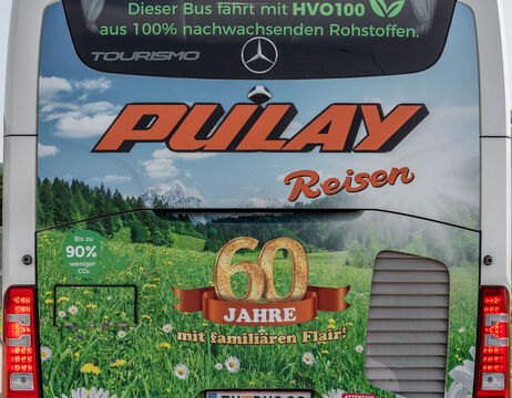 Die Rückseite eines Busses von Pulay Reisen mit der Aufschrift 60 Jahre