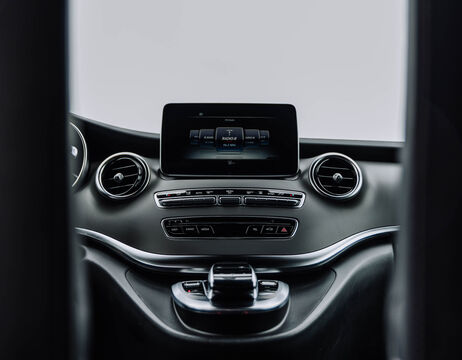 Armaturenbrett eines Autos mit zentralem Touchscreen-Display, Lüftungsdüsen und Bedientasten in einem modernen Fahrzeuginnenraum.