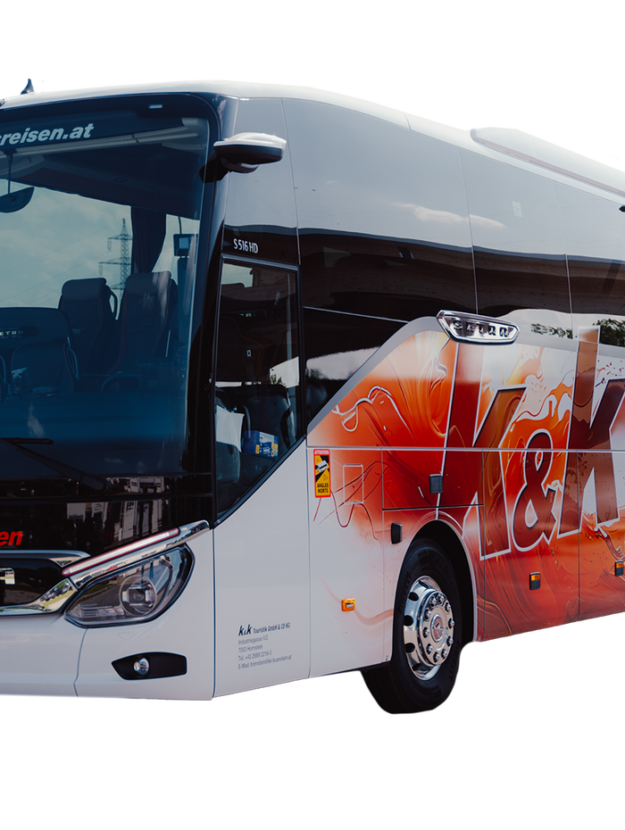 Ein moderner weiß-roter Reisebus mit dem Logo von K&K Busreisen auf der Seite, geparkt auf einem weißen Hintergrund.