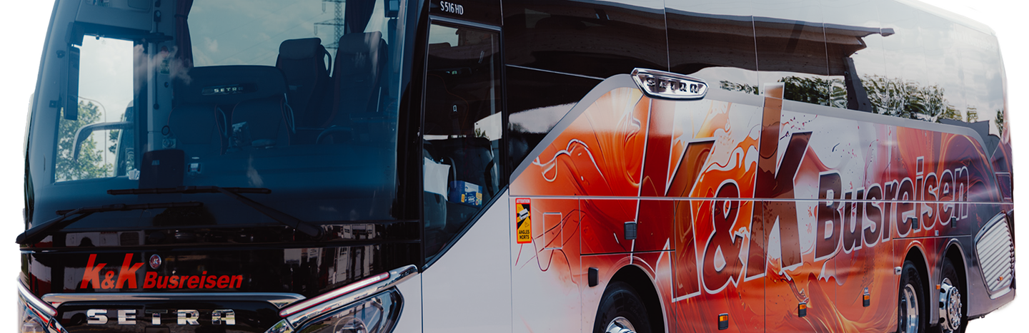Ein moderner weiß-roter Reisebus mit dem Logo von K&K Busreisen auf der Seite, geparkt auf einem weißen Hintergrund.