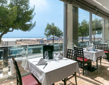 Ein Mann in traditioneller schottischer Kleidung spielt Dudelsack vor einer Steinmauer.