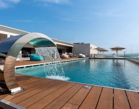 Ruinen einer Steinburg mit Blick auf einen großen See mit grünem Gras und Hügeln im Hintergrund.