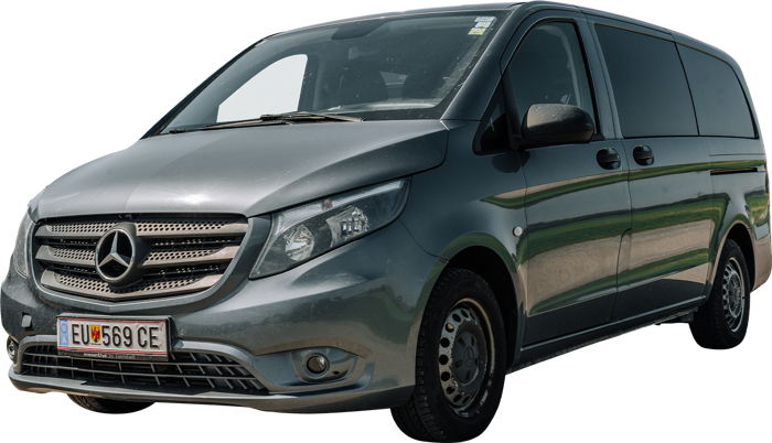 Ein silberner Mercedes-Benz Transporter, der an einem sonnigen Tag geparkt ist, von der linken Vorderseite aus gesehen.