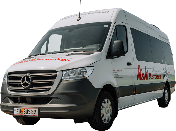 Weißer Mercedes-Benz-Kleinbus mit K&K Busreisen-Branding, geparkt an einem klaren Tag.