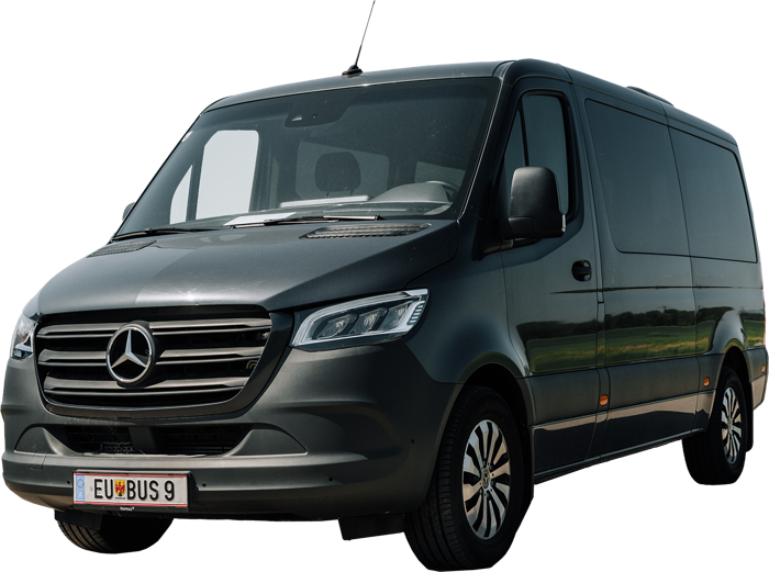 Ein grauer Mercedes-Benz Transporter mit europäischem Kennzeichen, geparkt an einem sonnigen Tag.