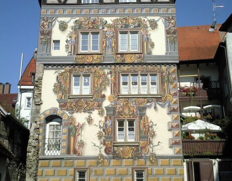 Ein Gebäude mit verschnörkelten, farbenfrohen Mustern und detaillierten Kunstwerken an der Fassade unter einem klaren blauen Himmel.