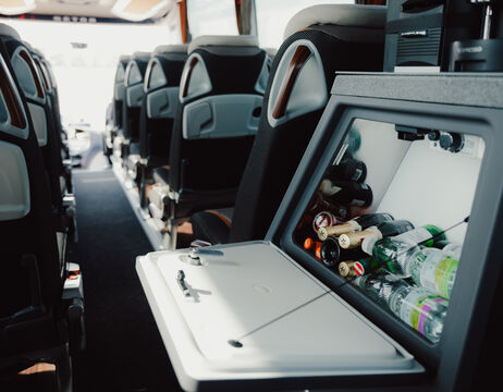 Entspannende Frau mit Klangschalen und Rosenblättern auf dem Rücken, auf einer Massageliege liegend, mit geschlossenen Augen.