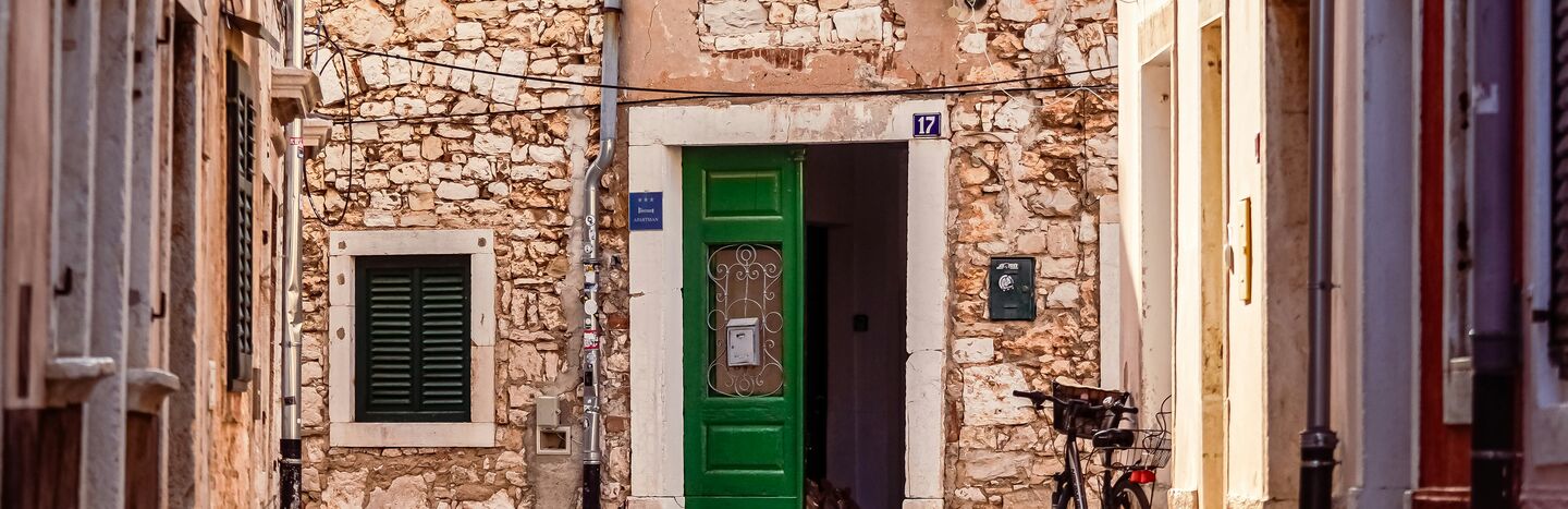 Eine Scheibe Schwarzbrot und ein Stück gewürzte Butter auf einem Metalltablett, garniert mit Petersilie.