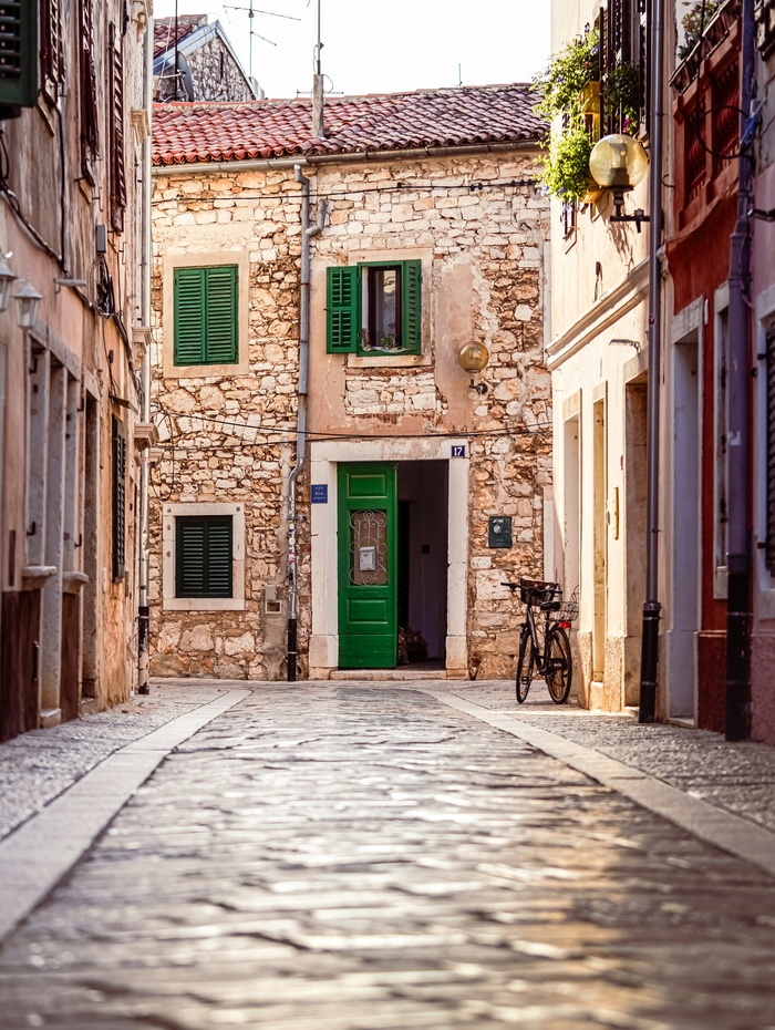 Eine Scheibe Schwarzbrot und ein Stück gewürzte Butter auf einem Metalltablett, garniert mit Petersilie.