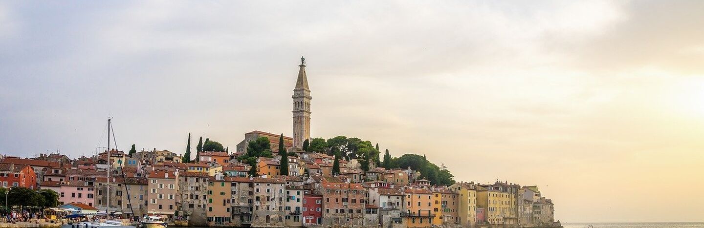 Zwei Fahrräder, die auf einem Kiesweg in einem grasbewachsenen Feld unter einem teilweise bewölkten Himmel abgestellt sind.