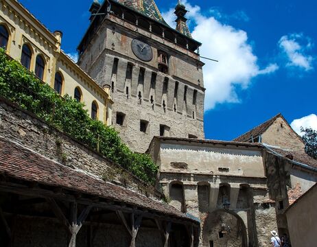 Mehrere Klarglasflaschen mit deutschen Etiketten stehen auf einem Holzfass in rustikaler Brennerei-Atmosphäre.