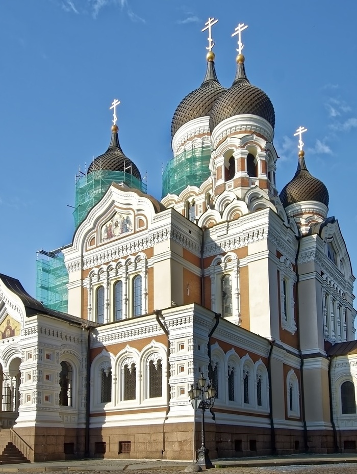 Orthodoxe Kathedrale mit Zwiebeltürmen und Baugerüsten vor einem strahlend blauen Himmel.