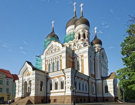 Orthodoxe Kathedrale mit Zwiebeltürmen und Baugerüsten vor einem strahlend blauen Himmel.