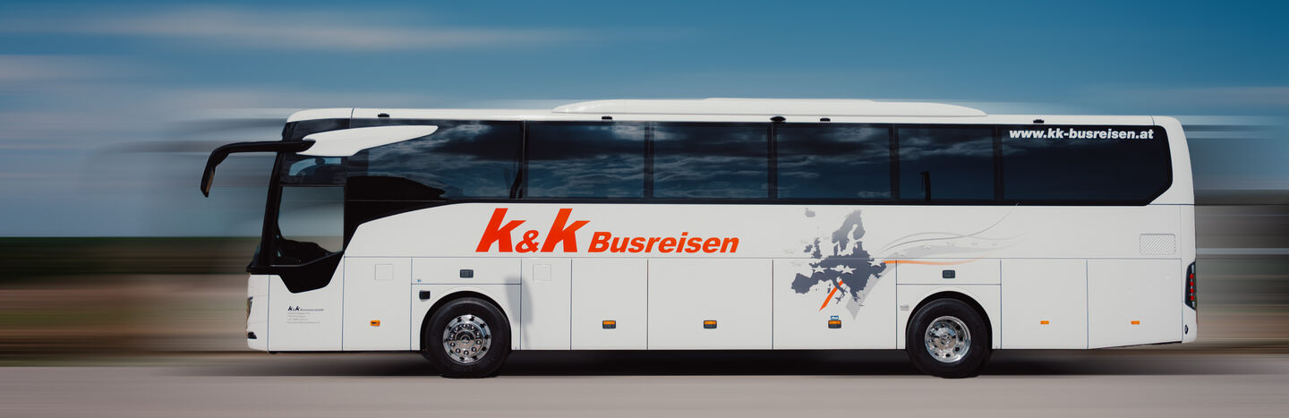 Überfüllter Strand mit schwimmenden und sonnenbadenden Menschen in der Nähe eines großen Hotels am Meer unter strahlend blauem Himmel.